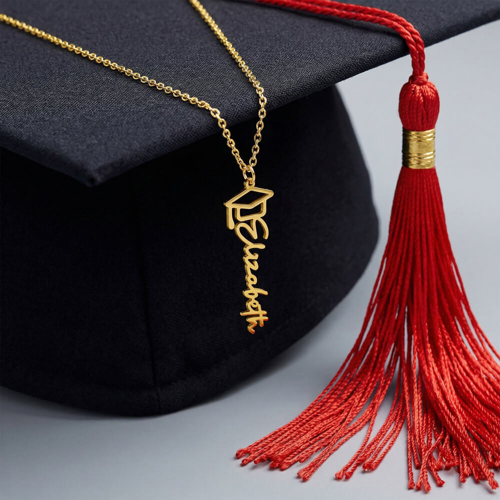 black graduation cap and red tassles with name necklace draped over the cap